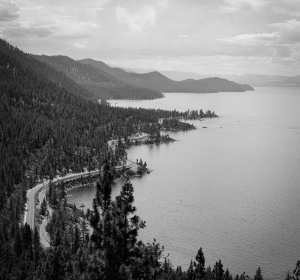 black and white photo overlooking the oceans with mountains on the side